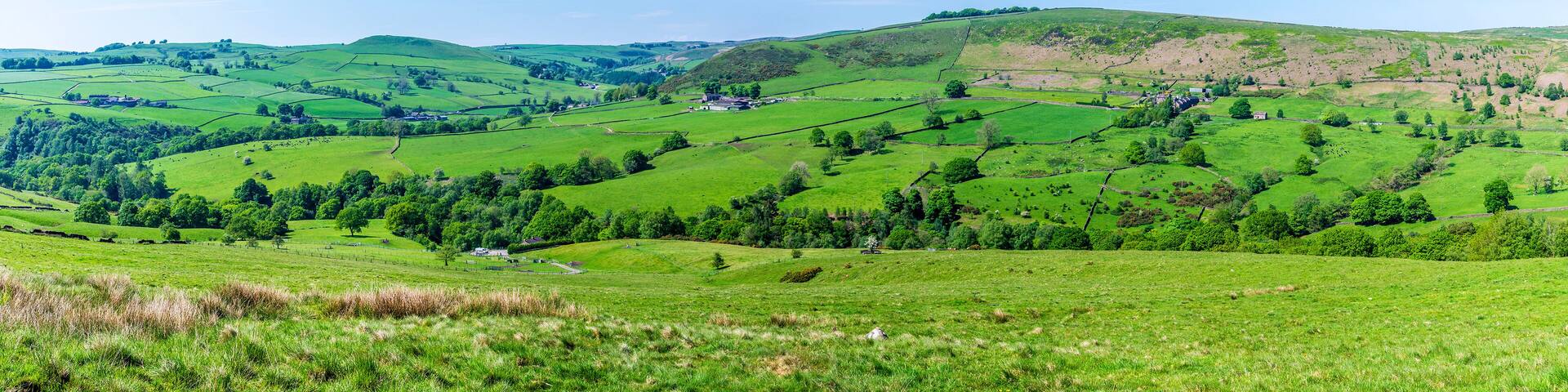 A panoramic view across the dales towards farmland from the path leading to Luds Church in Staffordshire in summertime