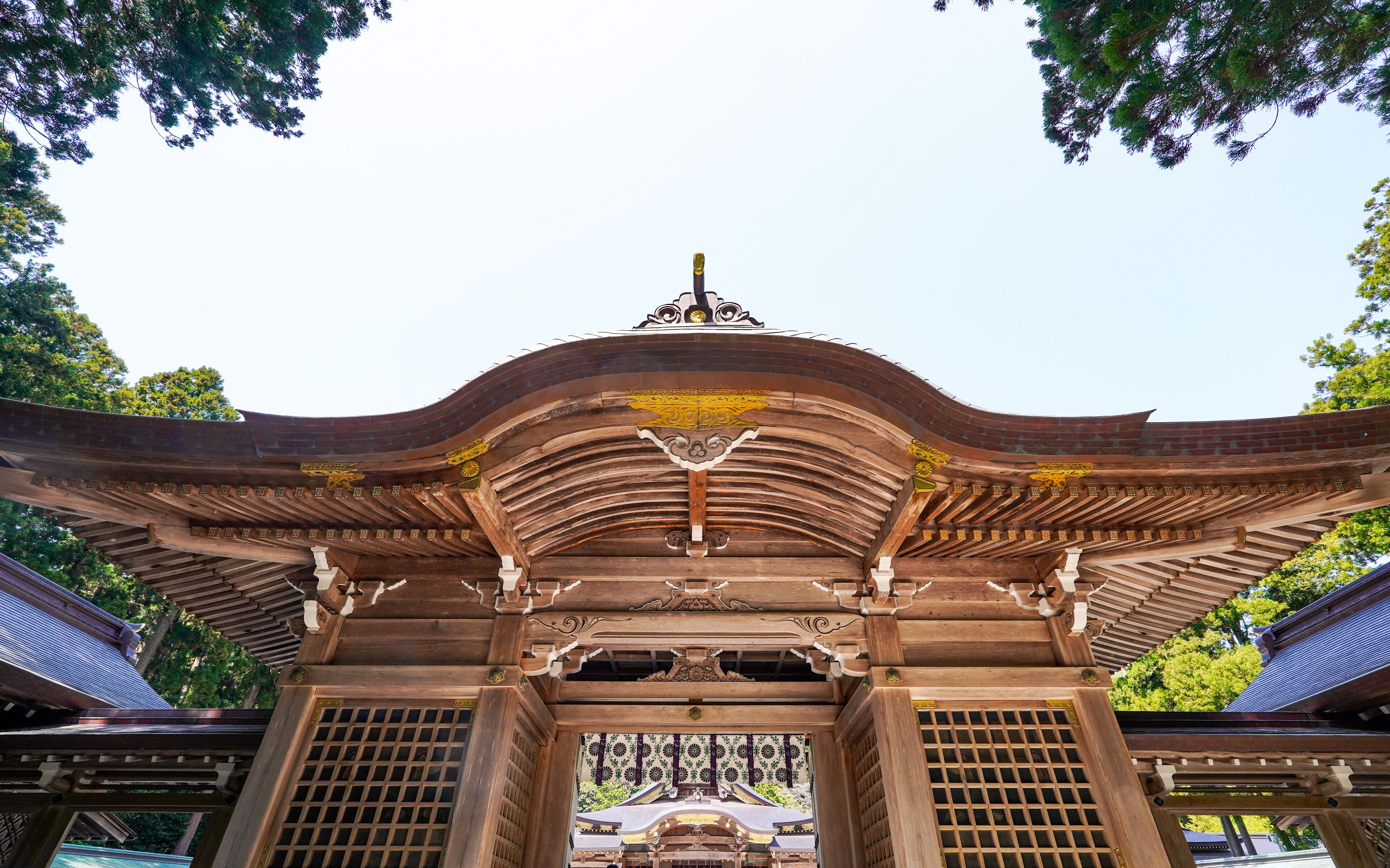 A traditional wooden gate with intricate carvings and a curved roof.