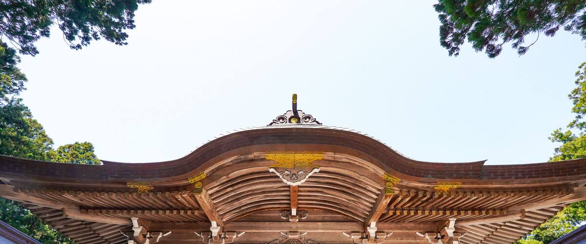 A traditional wooden gate with intricate carvings and a curved roof.