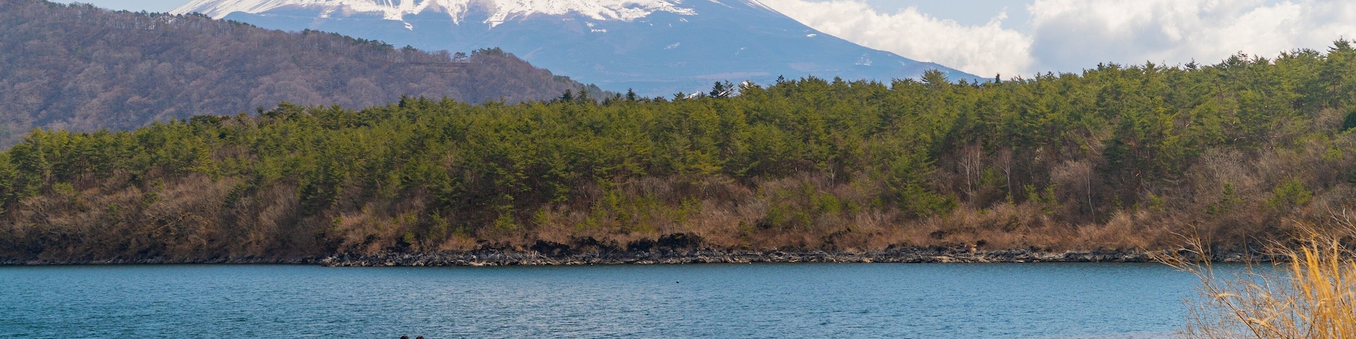 Lake Saiko featuring mountains, a lake or waterhole and snow