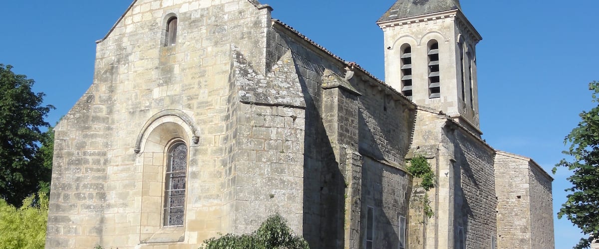 A historic stone church with a tall steeple and a bell tower.