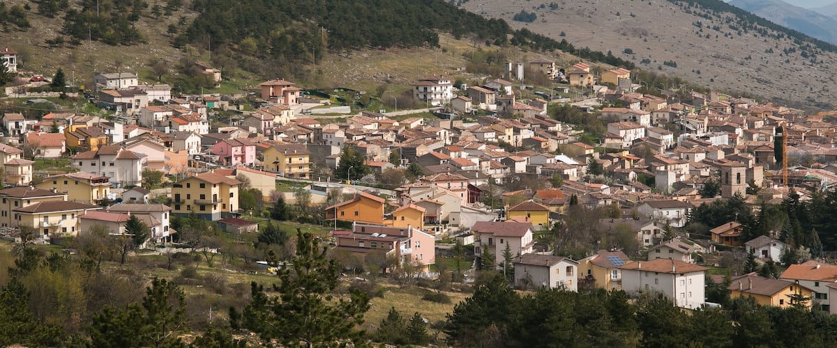 A town nestled in a valley with mountains in the background.