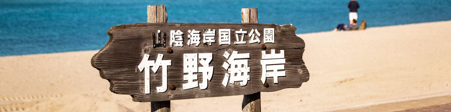 Takeno Beach featuring signage, general coastal views and a sandy beach