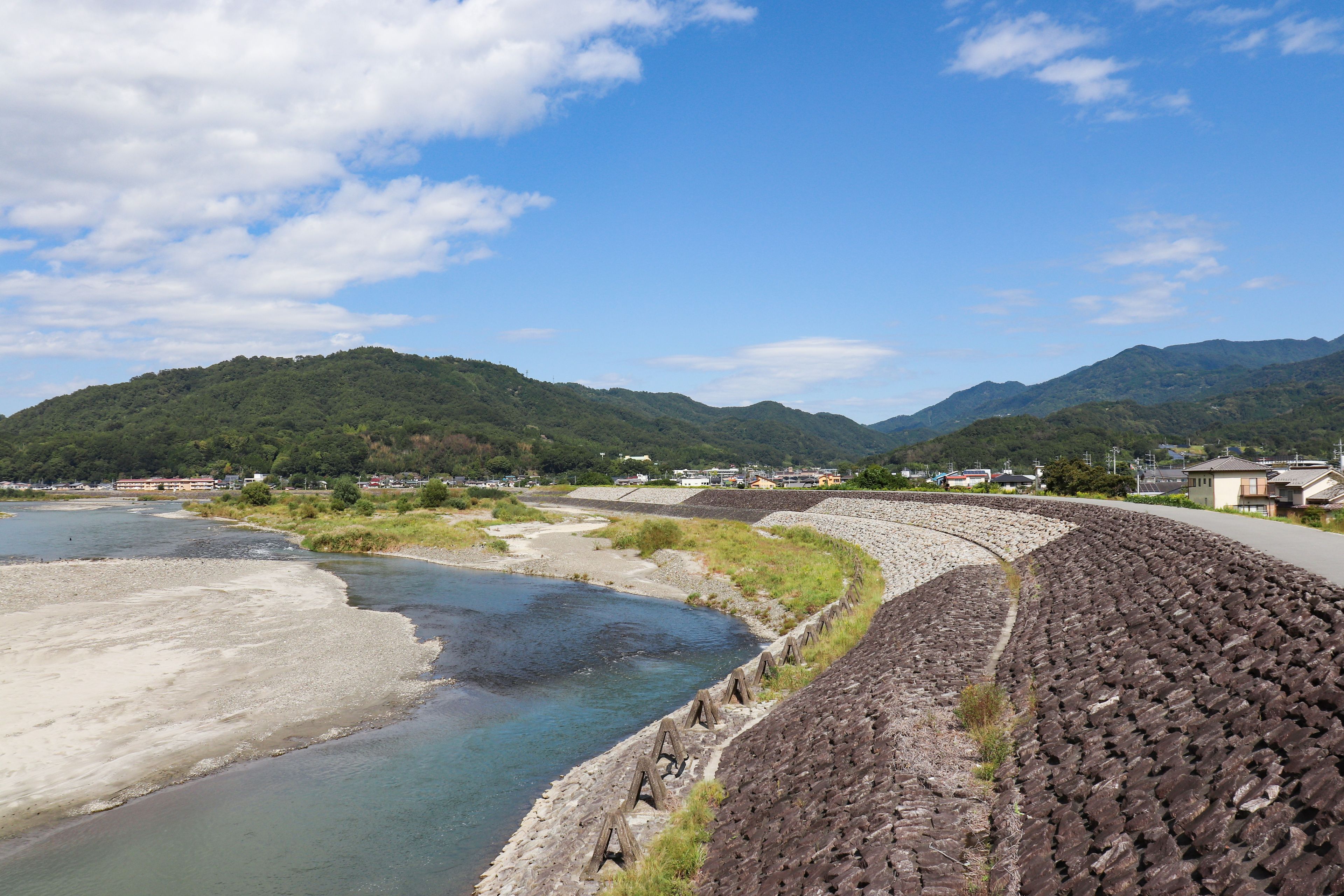 Un río serpentea por un valle con montañas al fondo.