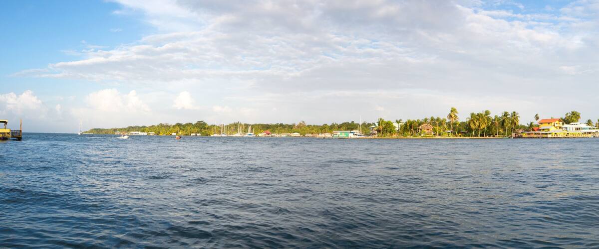 A coastal town with a pier, boats, and a clear sky.