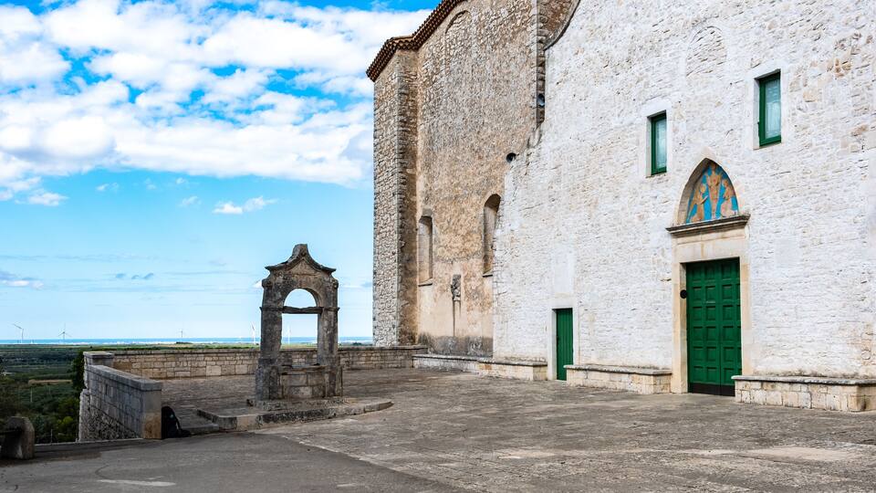 A historic stone building with a green door and a stone archway.