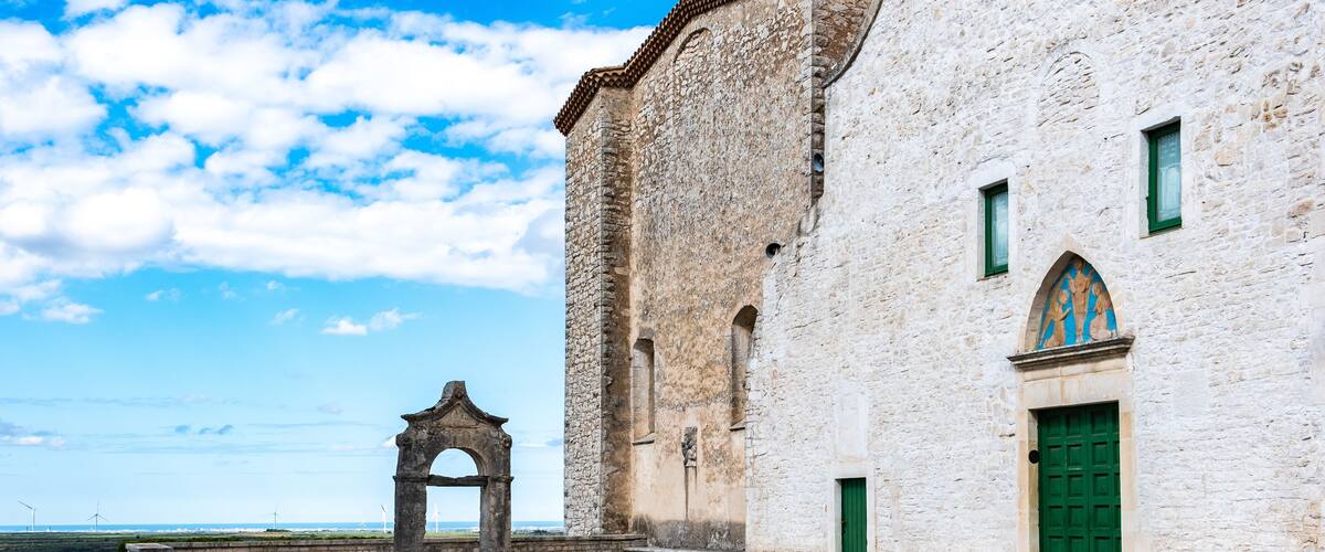 A historic stone building with a green door and a stone archway.