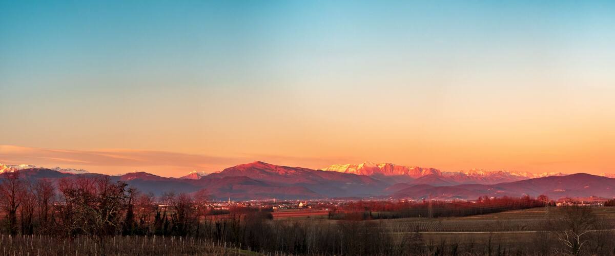 A mountain range at sunset with a town in the valley.