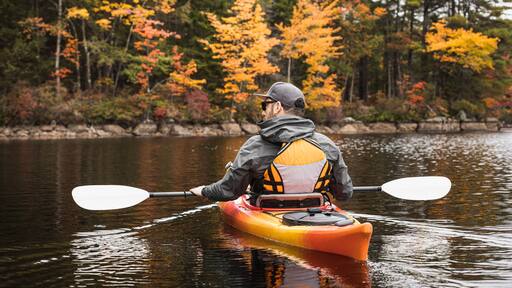 Kayaker Paddling on a New Hampshire Pond in Autumn