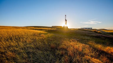 A field with a launch tower and a building in the background.