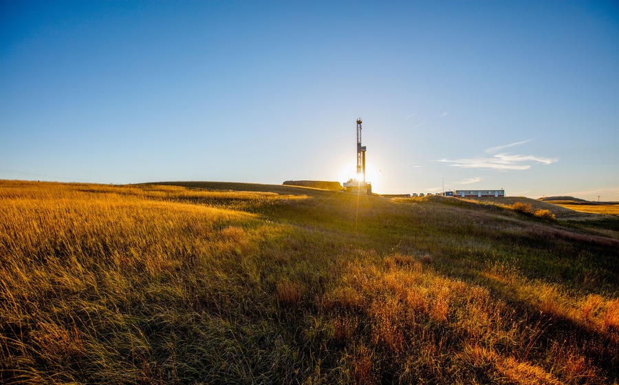 Oil pump on field against blue sky
