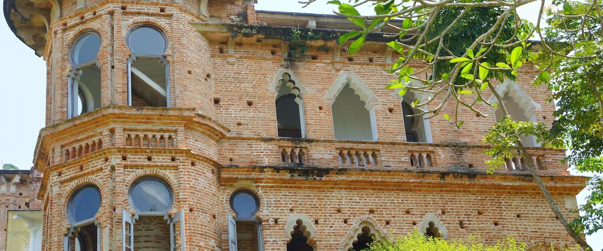 A historic brick building with arched windows and a turret.