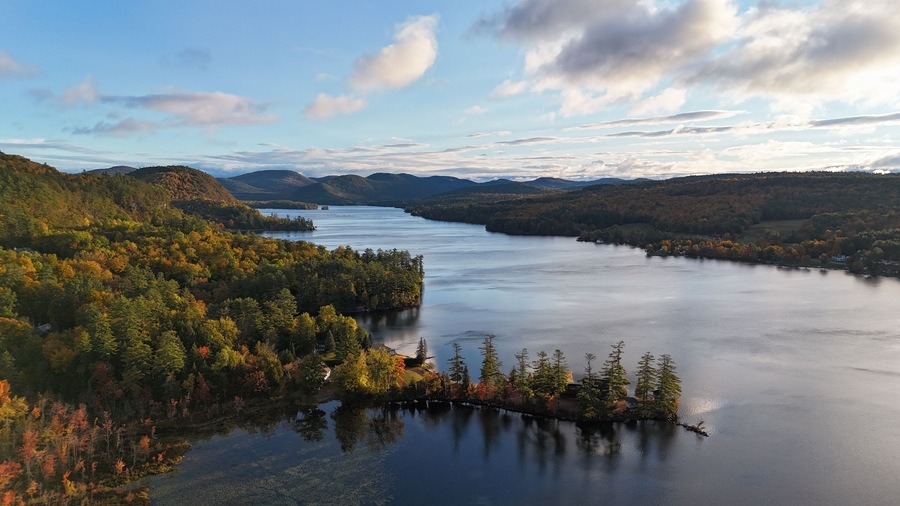 A lake surrounded by forested hills with autumn foliage.