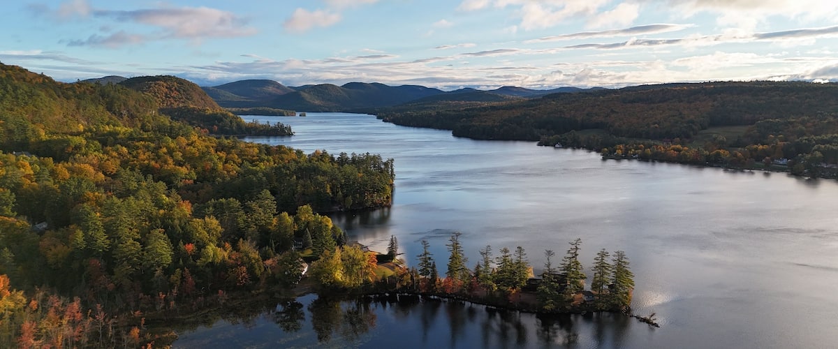 A lake surrounded by forested hills with autumn foliage.