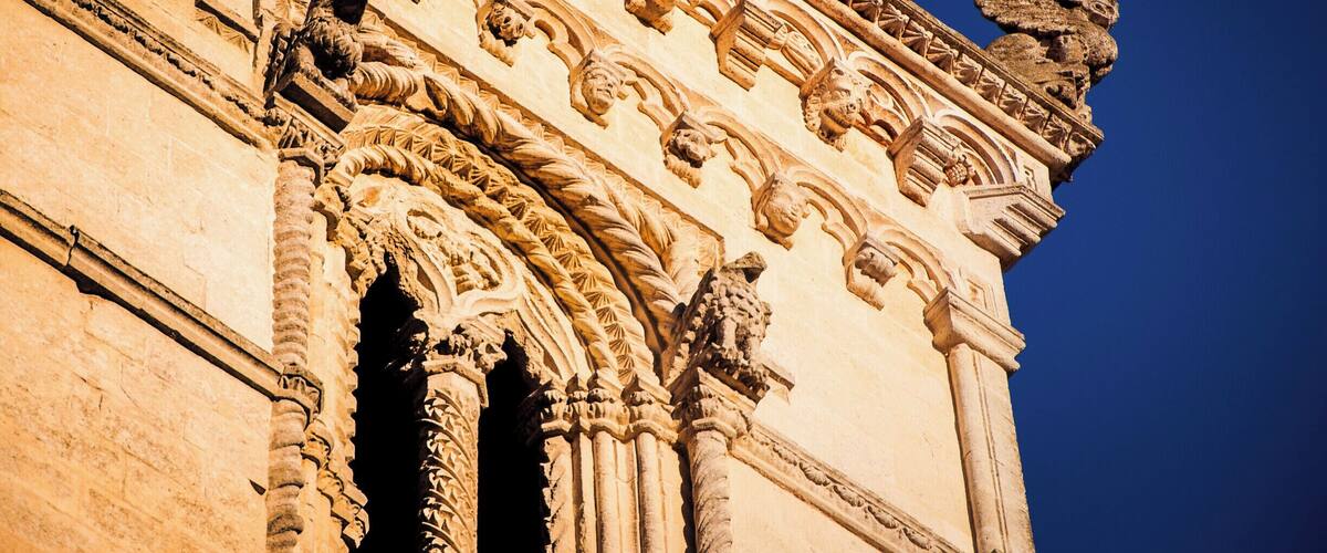 A detailed stone facade with intricate carvings and a prominent lion statue.