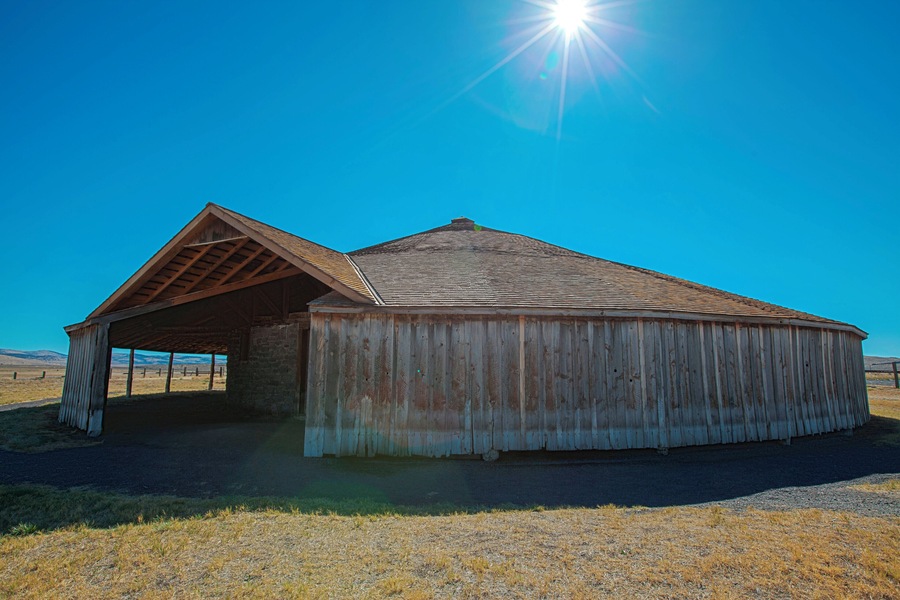 The Pete French Round Barn stands in the heart of Harney County and remains a monument to one man’s livestock empire. Peter French arrived in 1872 and began amassing land and cattle. By the mid-1880s, his enterprise had grown to 70,000 acres and 45,000 head of cattle.
Some claimed he didn’t legally acquire the land or water rights, which prompted land disputes and court cases and added to his controversial reputation. One of the disputes eventually led to his murder in 1897.
Although dubbed the ‘Cattle King,” French was the first rancher in the area to put up hay. He also raised thousands of sheep for their wool. The Round Barn was used to train wild horses to pull long wagon trains full of wool, hay and supplies to market in Oregon City.
In today’s landscape, this type of barn is unique. But during 1880–1920, round barns became popular in the Midwest where they were promoted as being efficient for progressive methods of farming.
The Round Barn is near the Malheur National Wildlife Refuge, a network of wetlands that attract diverse bird and wildlife species. As you drive through the area, take in the sweeping views of the high buttes surrounding the low plains and marshes and the picturesque Steens Mountain towering in the distance.
#Oregon #PeteFrench #roundbarn #extremeOregon