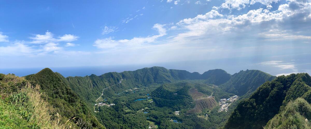 A mountainous landscape with dense greenery and a clear sky.