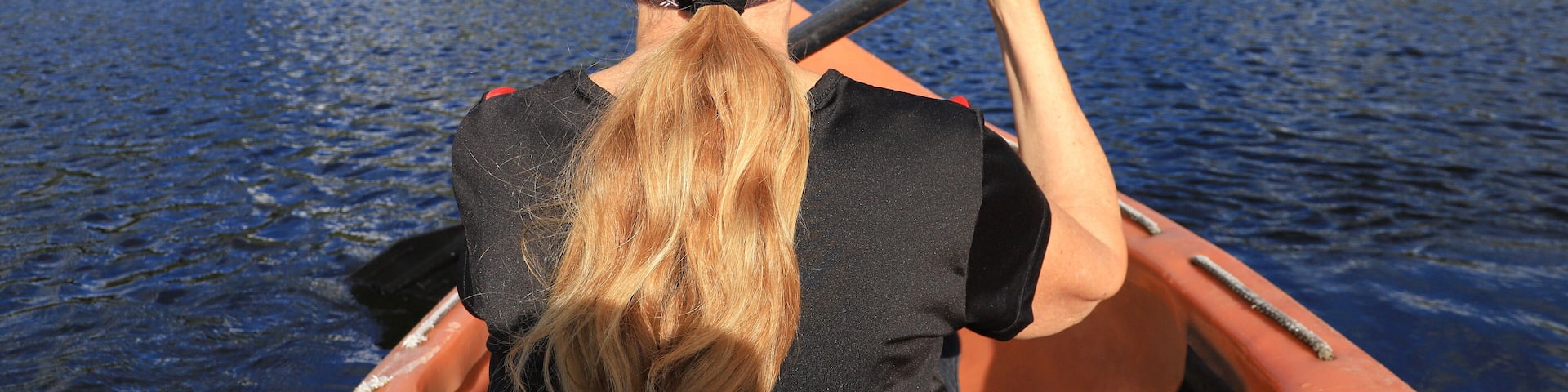A woman is paddling on lake Skredvatn, Fyresdal - South Norway