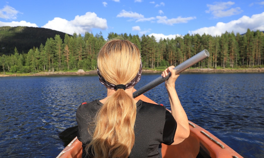 A woman is paddling on lake Skredvatn, Fyresdal - South Norway