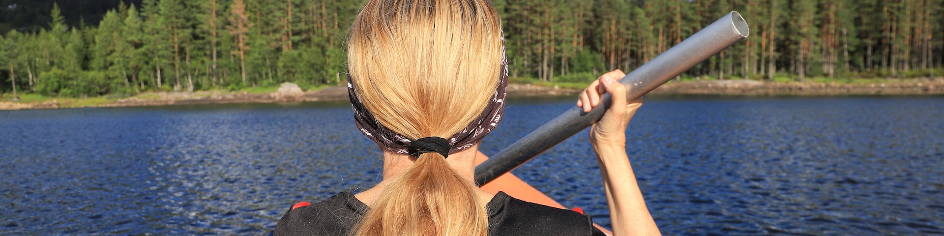 A woman is paddling on lake Skredvatn, Fyresdal - South Norway