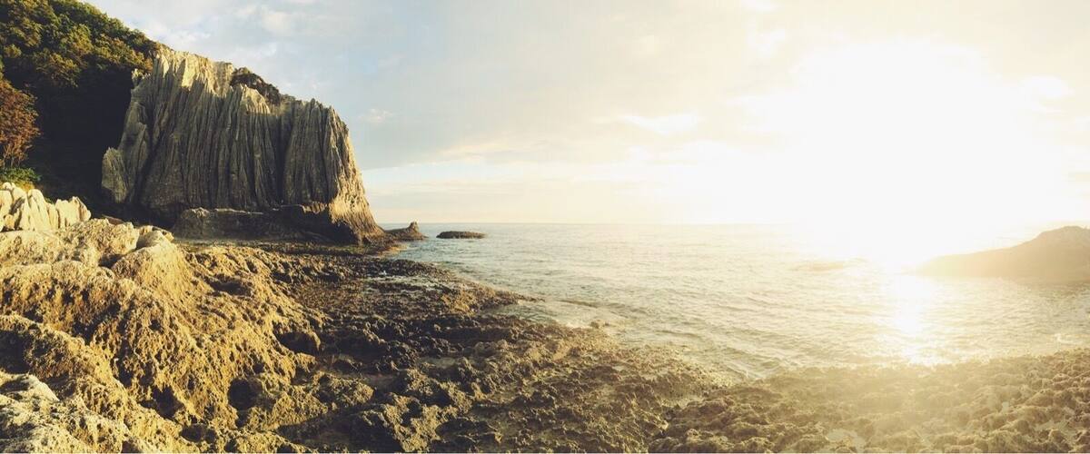 A coastal landscape with rocky cliffs and a calm sea.