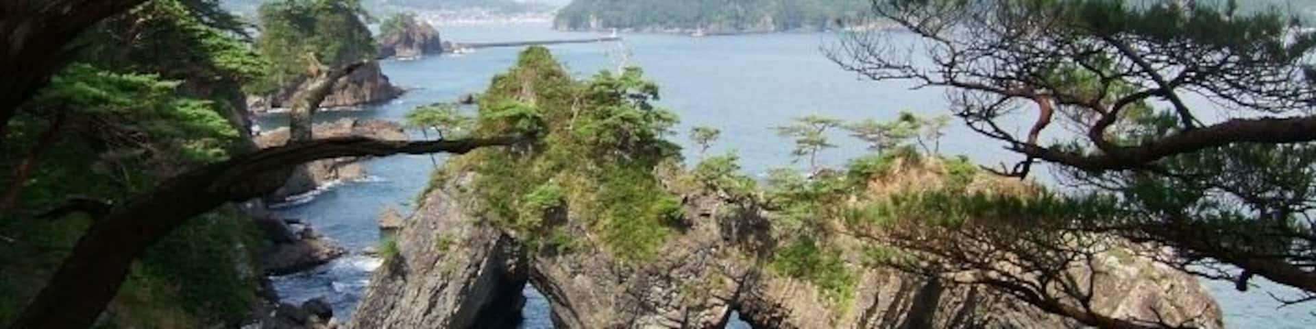 A coastal landscape with rocky formations and clear blue water.