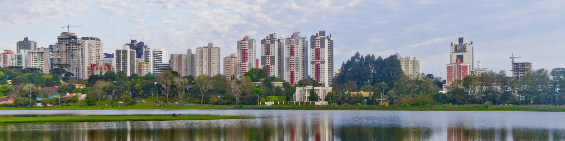 Trees and bulding reflections on lake at Birigui Park.