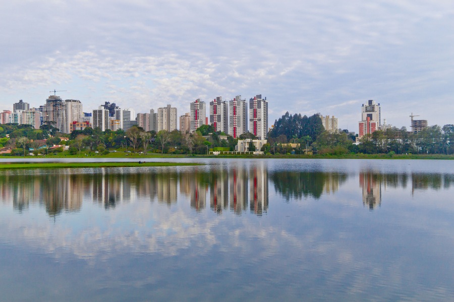 Trees and bulding reflections on lake at Birigui Park.