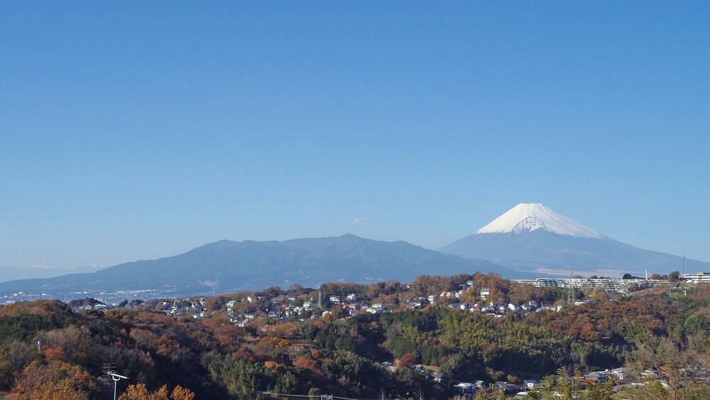 Eine Stadt mit Häusern und einem Berg im Hintergrund.