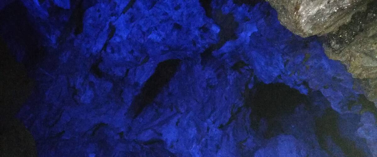 A cave interior with blue lighting and rocky formations.