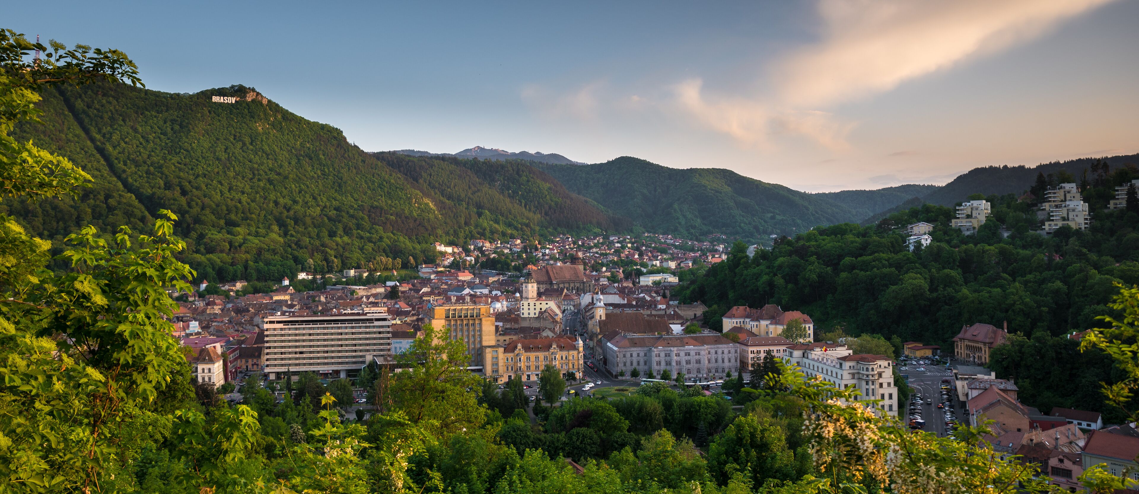 A city nestled in a valley with mountains in the background.