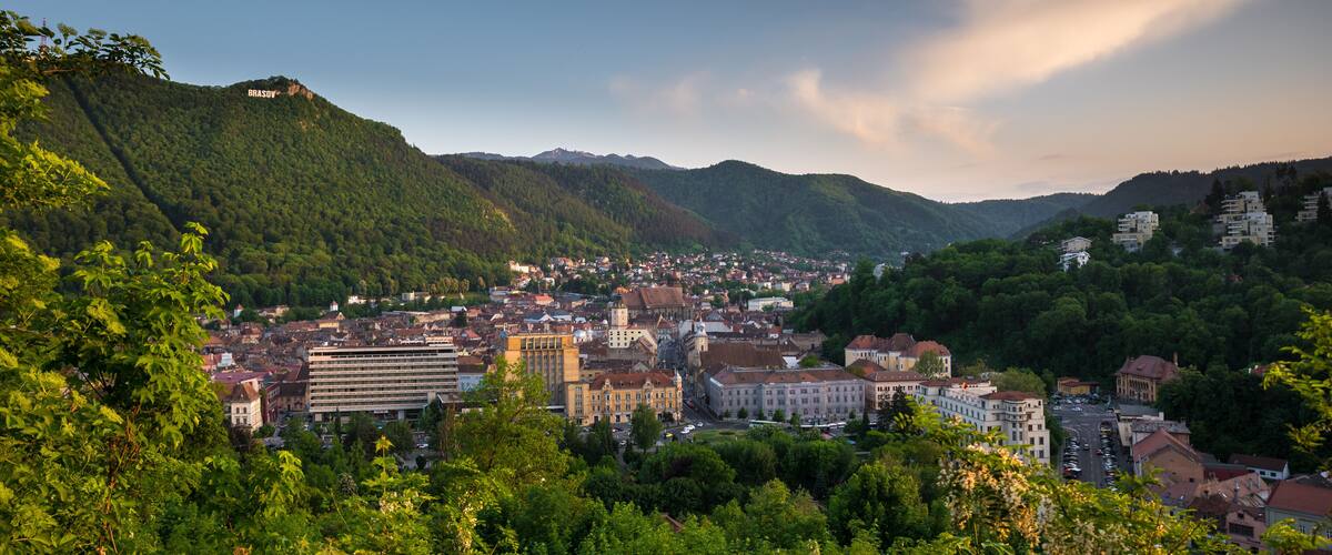 A city nestled in a valley with mountains in the background.