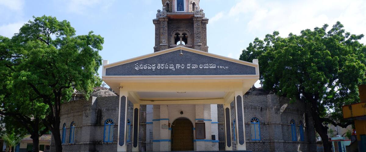 A church with a bell tower and a covered entrance.
