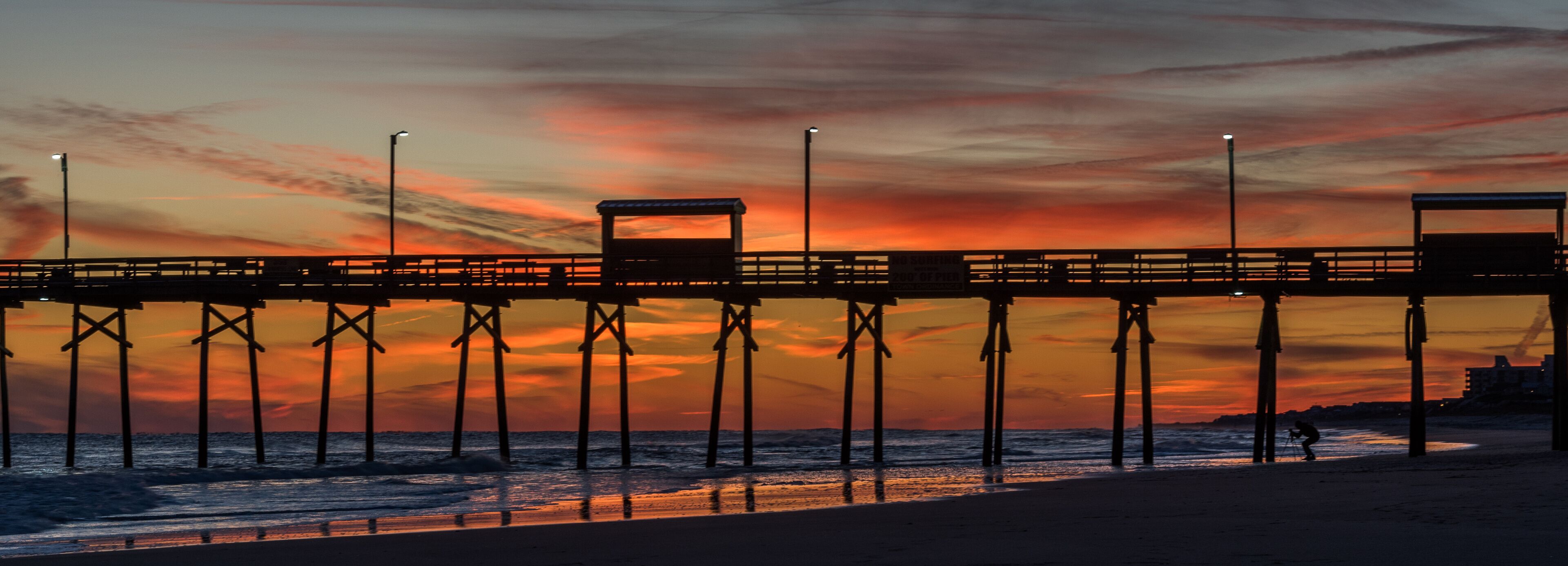 A pier at sunset with a vibrant sky.