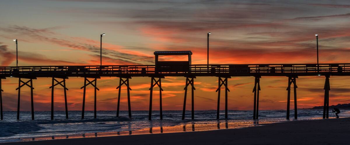 A pier at sunset with a vibrant sky.