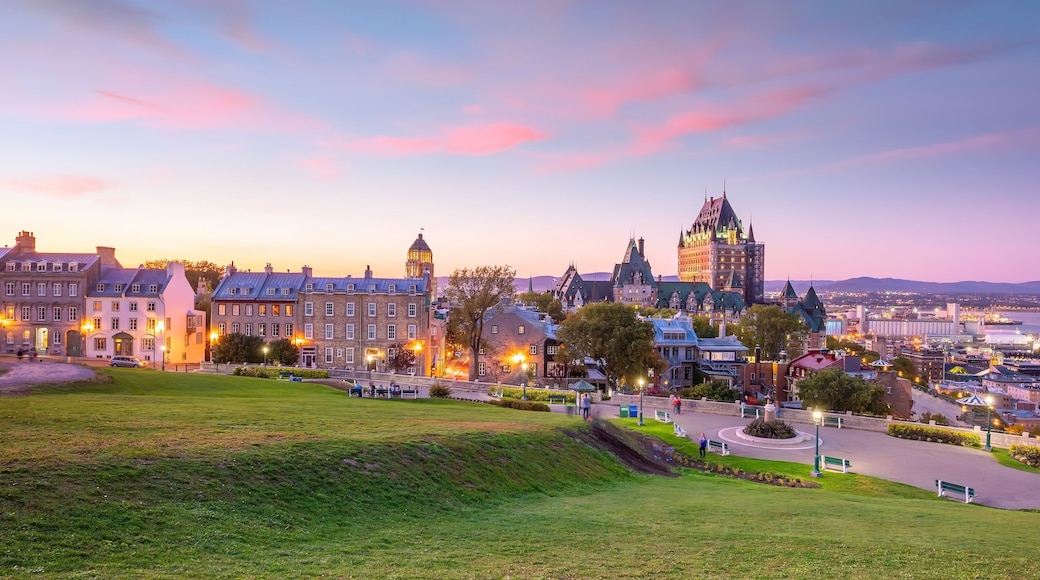 Un paisaje urbano costero al atardecer, con edificios históricos, una destacada torre del reloj y un paseo marítimo.