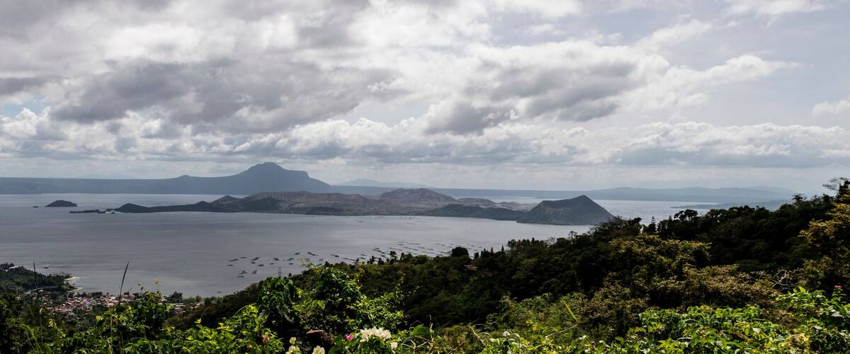 A coastal landscape with a large body of water, several small islands, and a mountainous backdrop.