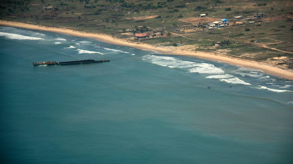 Aerial view of a disassembled ship wreckage off the coast of Ghana