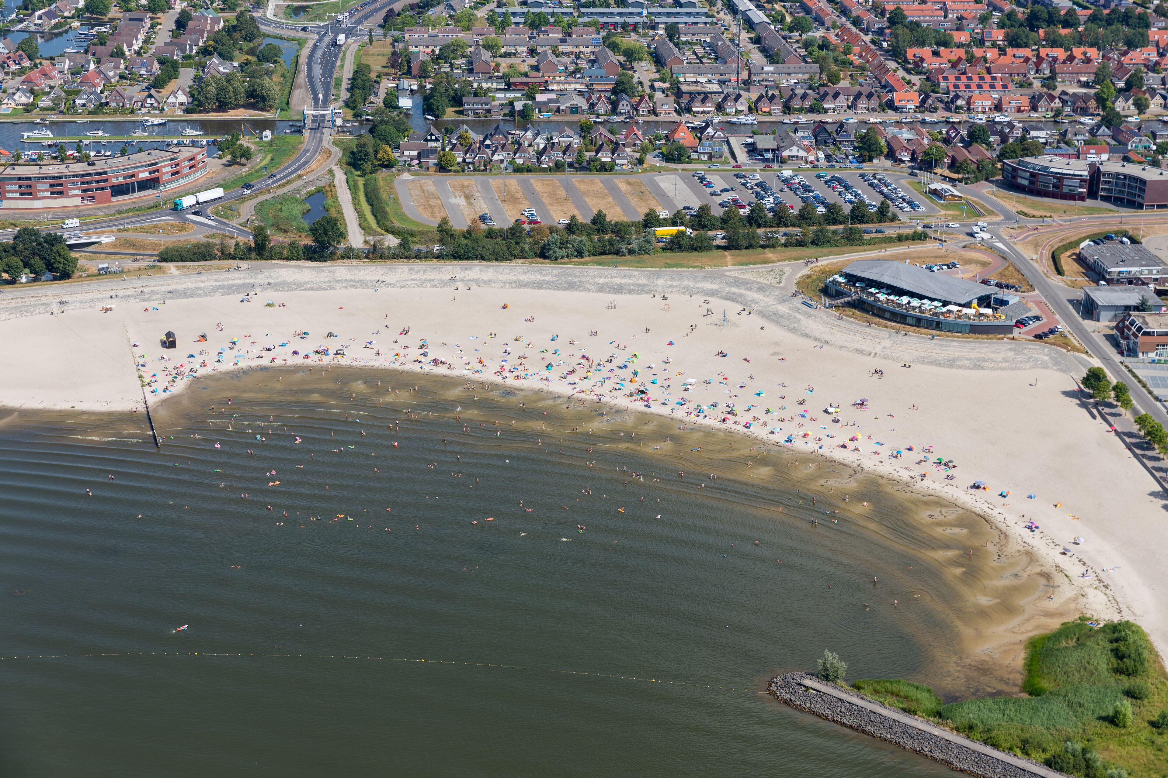Aerial view beach Dutch village Lemmer with relaxing and swimming people at a hot summer day