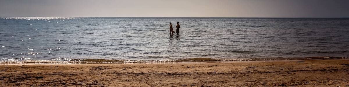 Bluewater Beach, Township of Tiny, Ontario, Canada - August 10, 2014: Young couple frolic in Georgian Bay on a warm, late summer afternoon.