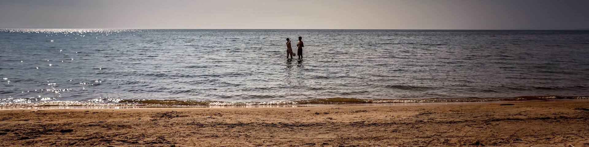 Bluewater Beach, Township of Tiny, Ontario, Canada - August 10, 2014: Young couple frolic in Georgian Bay on a warm, late summer afternoon.