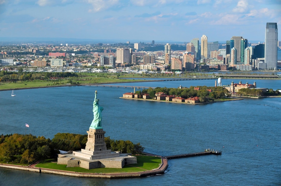 Die Freiheitsstatue auf Liberty Island, die Skyline von Manhattan und der Hudson River.