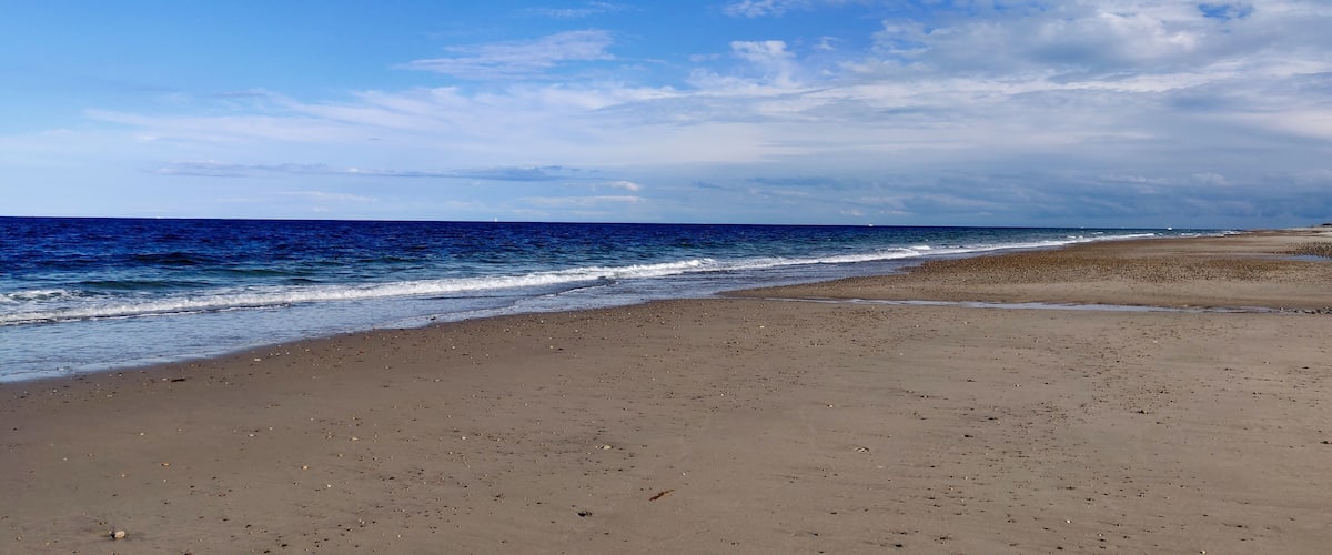 A beach with a clear sky and ocean waves.