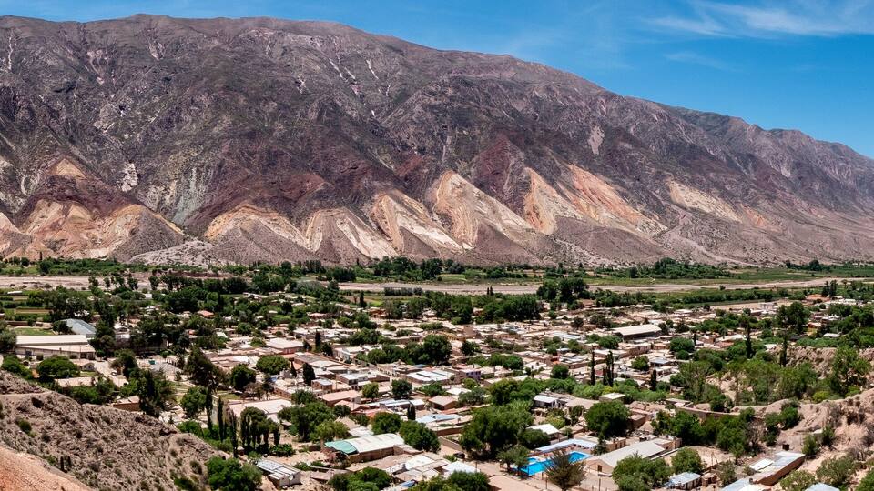 A town nestled in a valley with mountains in the background.