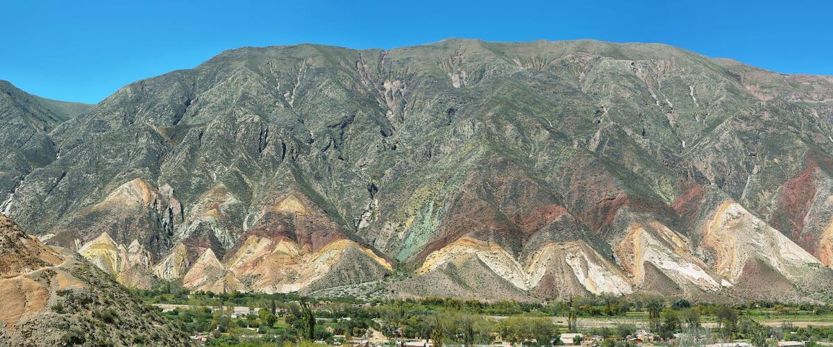 A mountain range with distinct geological layers and a valley below.