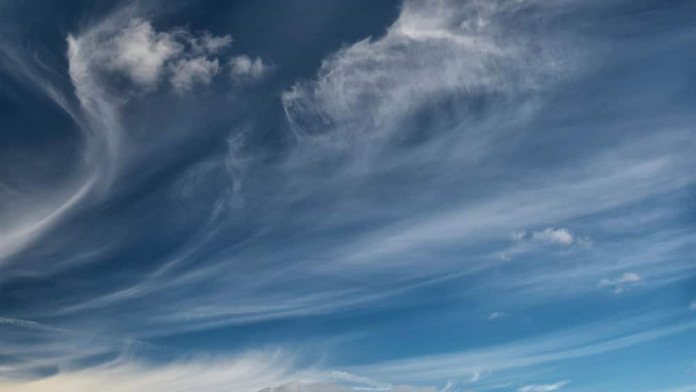 Ein weites Feld unter einem Himmel mit einer großen, wirbelnden Wolkenformation.