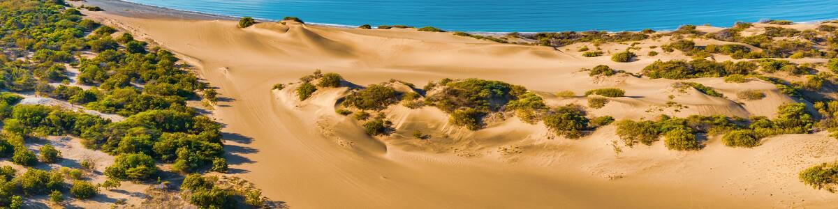 Panoramic aerial view of the dunes of Bani on a sunny day with the Caribbean Sea behind on a sunny day, Peravia, Dominican Republic