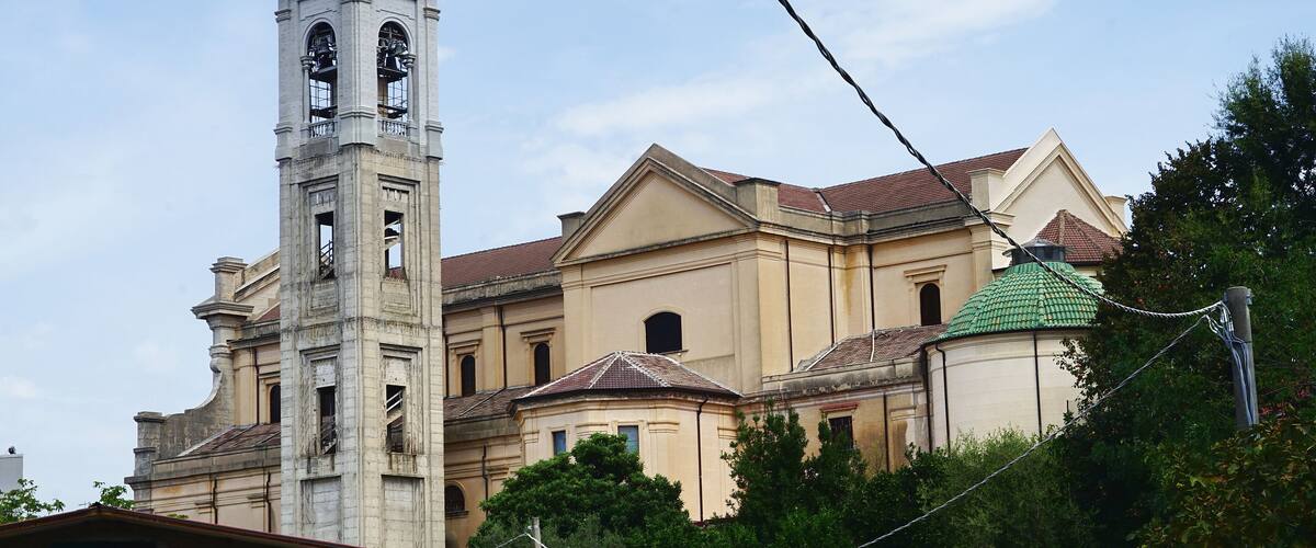 A historic building with a bell tower and a green-roofed dome.