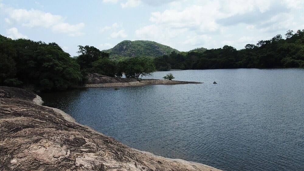 Un lac paisible, entouré d’un paysage rocheux et d’une forêt dense.