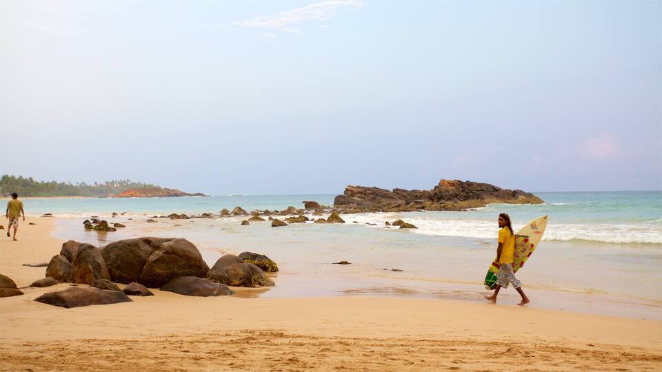 A beach with large rocks and calm water.